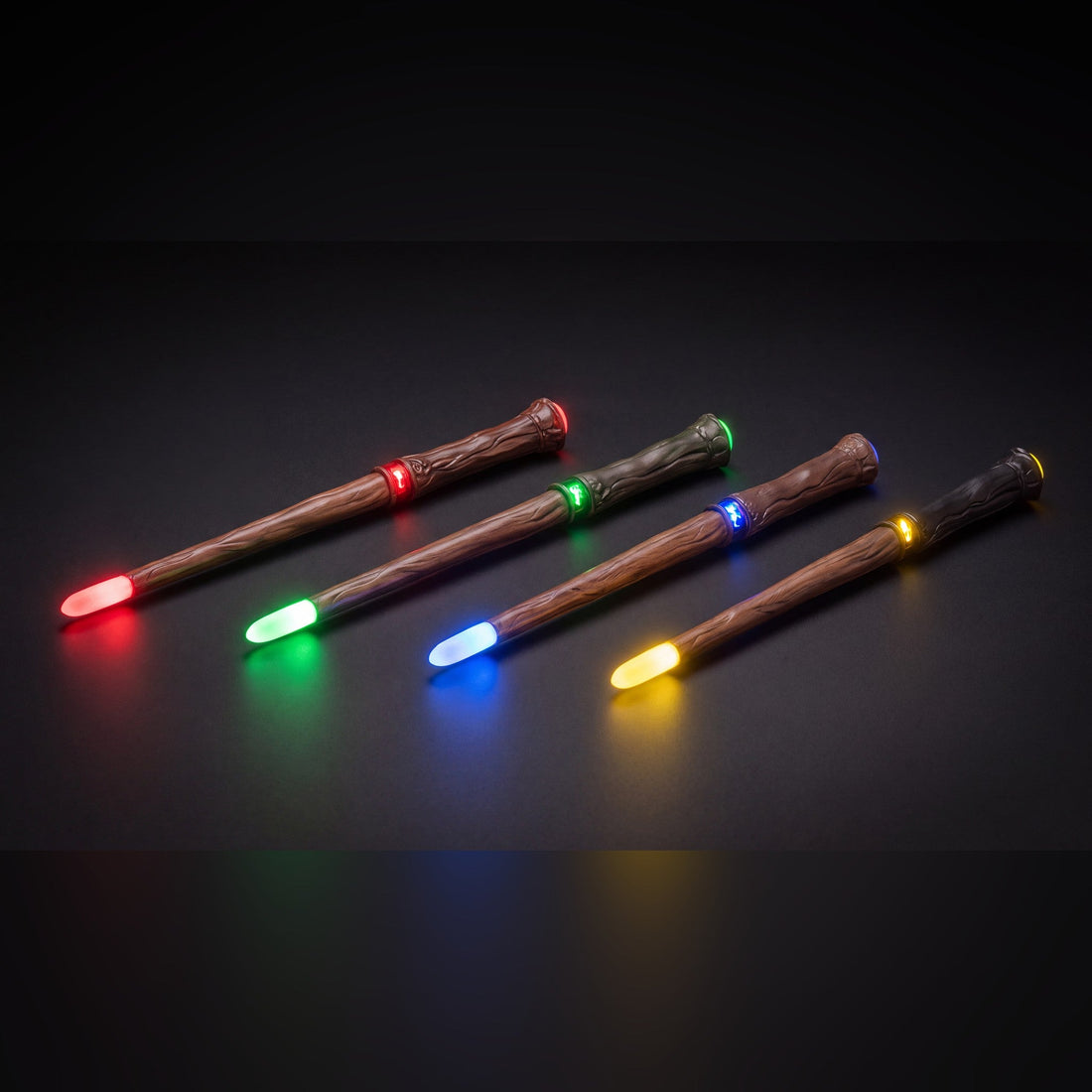 The 4 carved wood-look wands with red, green, blue and yellow crystal tips